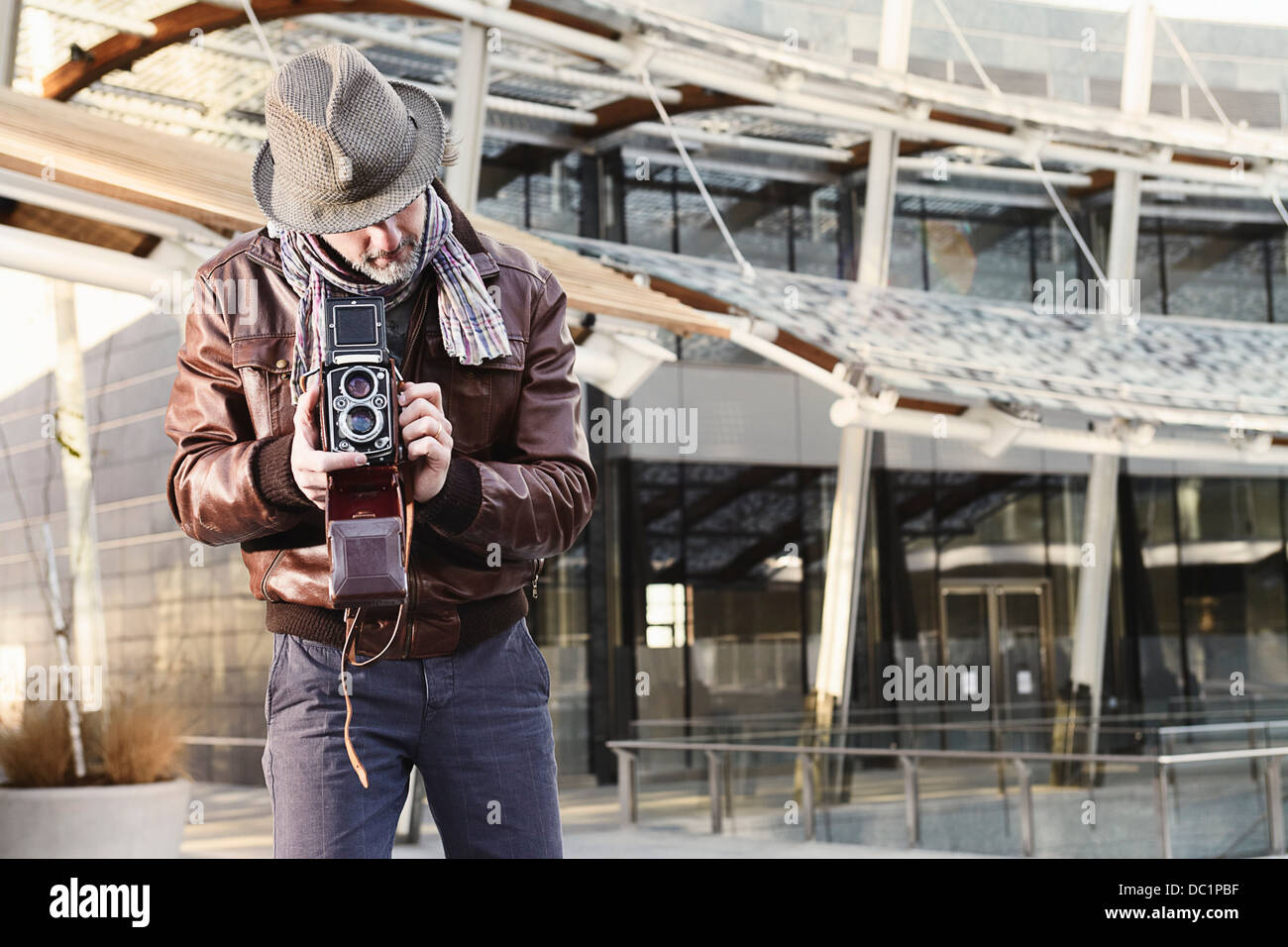 Mid adult man using twin lens reflex camera Stock Photo