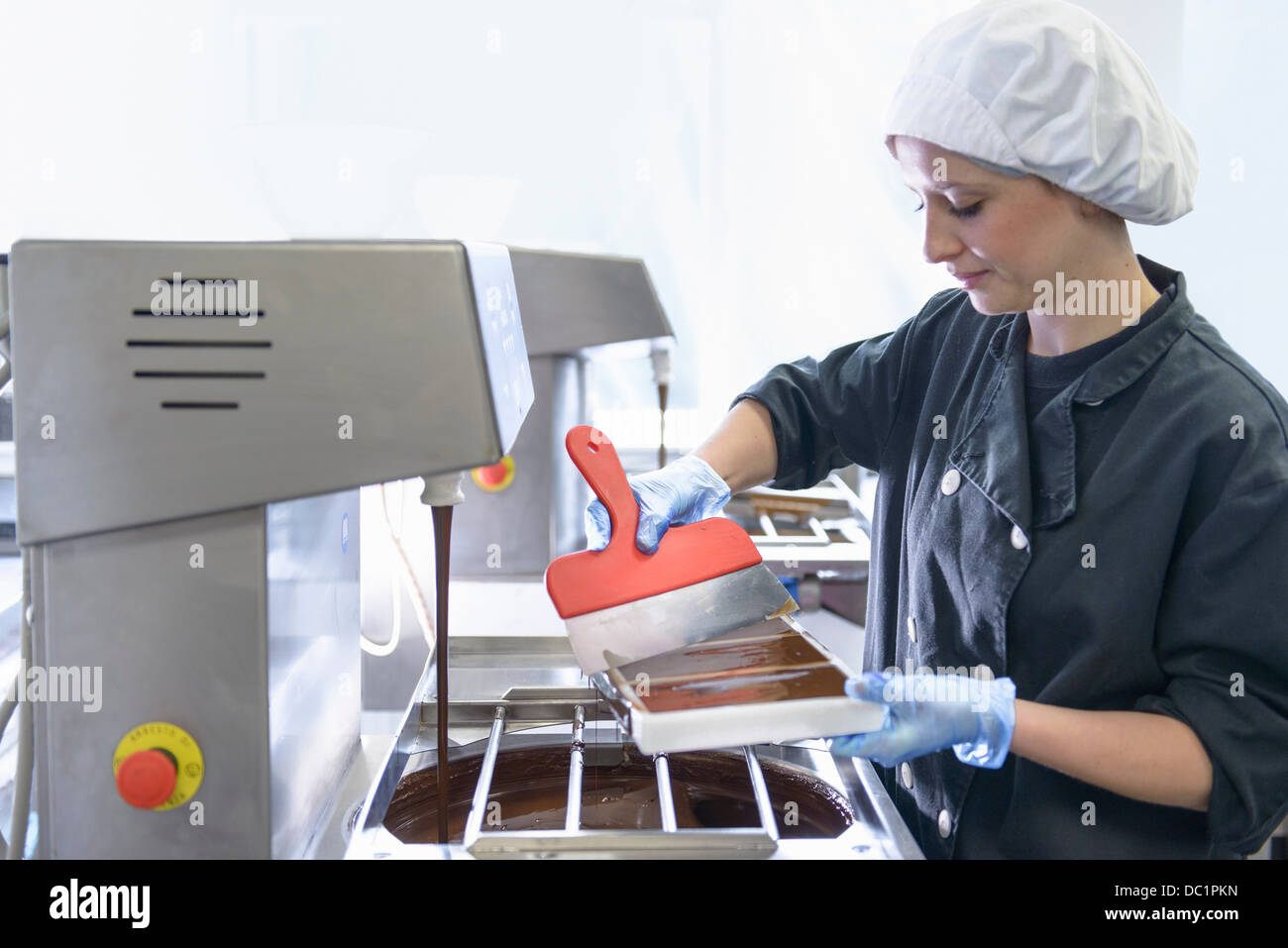 Chocolatier smoothing chocolate in moulds Stock Photo