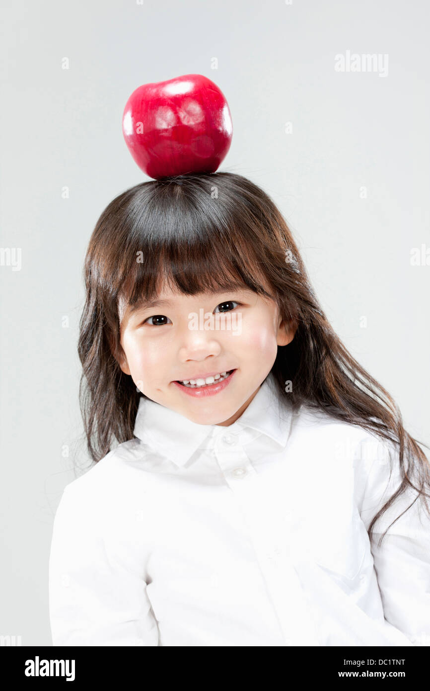 a girl with a red apple on her head Stock Photo Alamy