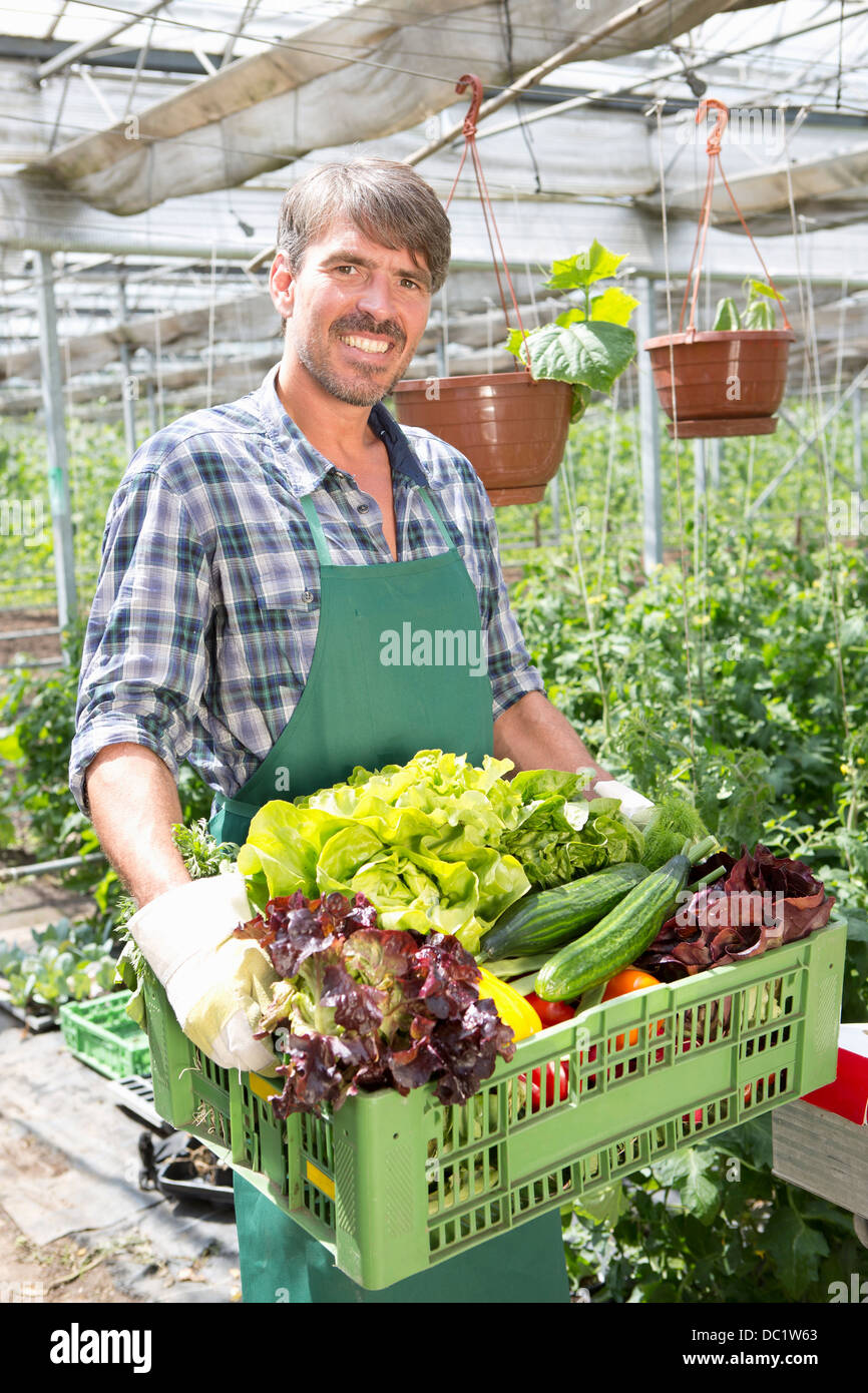 Portrait of organic farmer carrying a tray of fresh produce Stock Photo ...