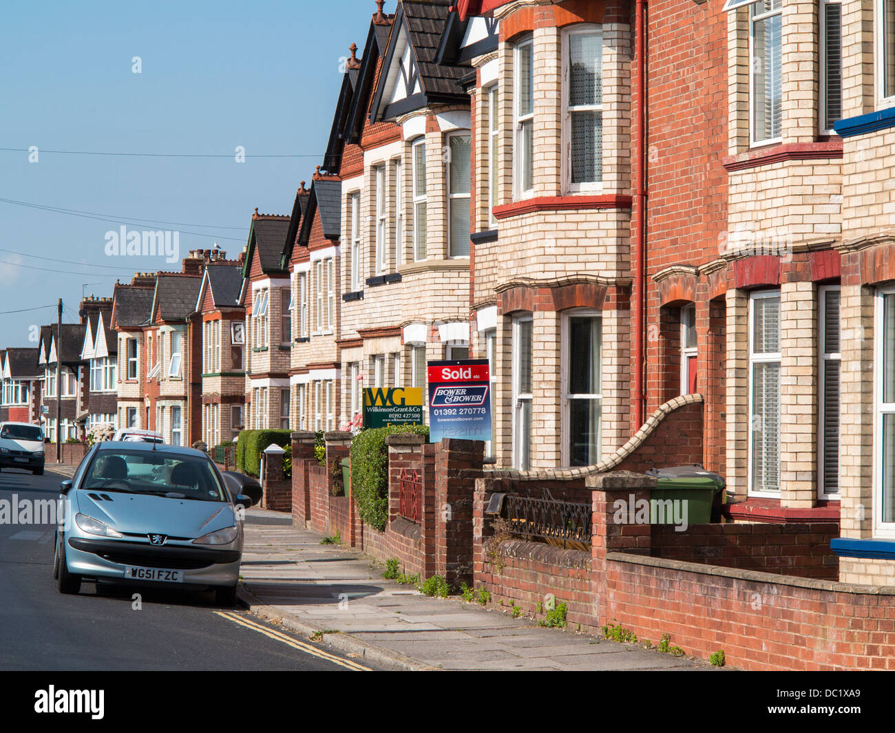 Row of terraced houses with sold sign on one of them, Exeter, Devon, England Stock Photo