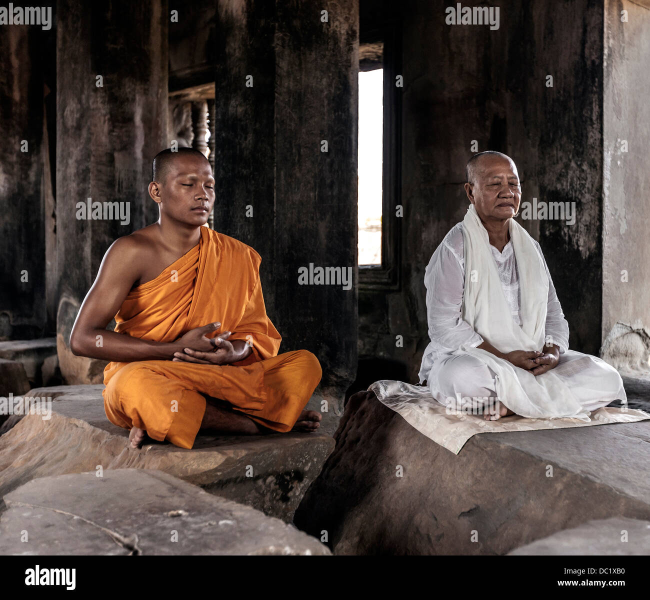 Senior and young monk meditating in temple in Angkor Wat, Siem Reap, Cambodia Stock Photo