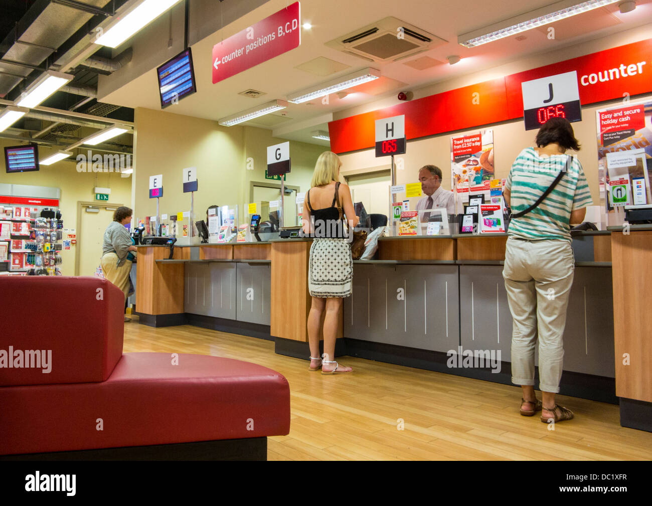 Post Office counter with people waiting at Exeter, Devon, England Stock