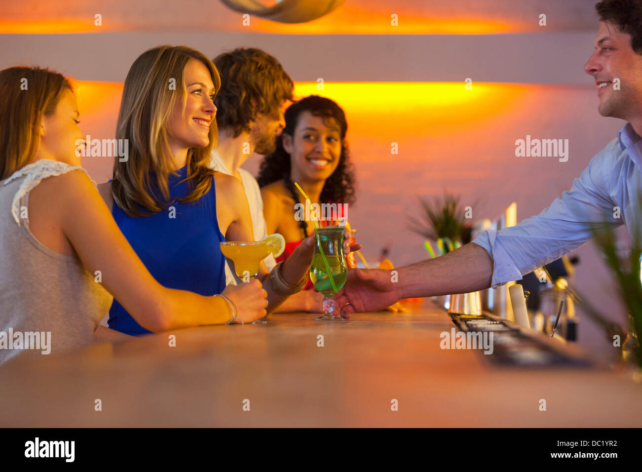 Group of friends ordering cocktails in bar Stock Photo