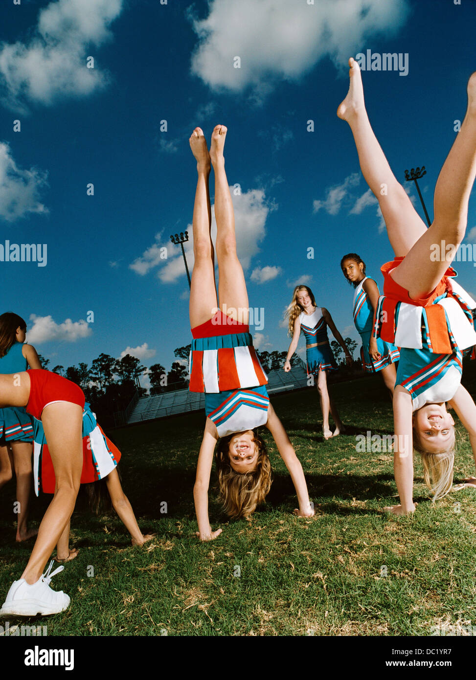 Cheerleaders performing handstands on pitch Stock Photo