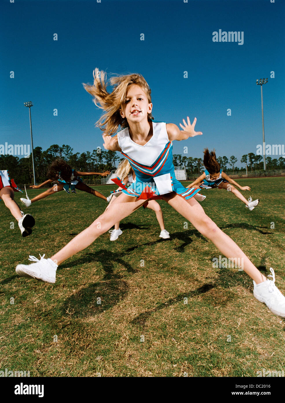Cheerleaders performing dance routine on sports field Stock Photo