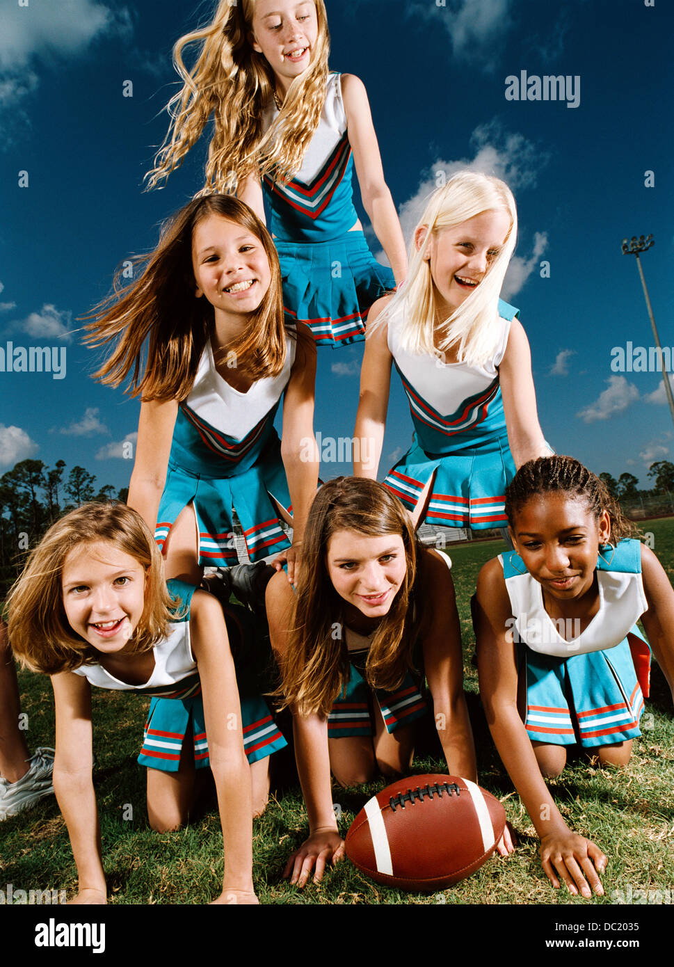 Cheerleaders kneeling on top of each other, portrait Stock Photo