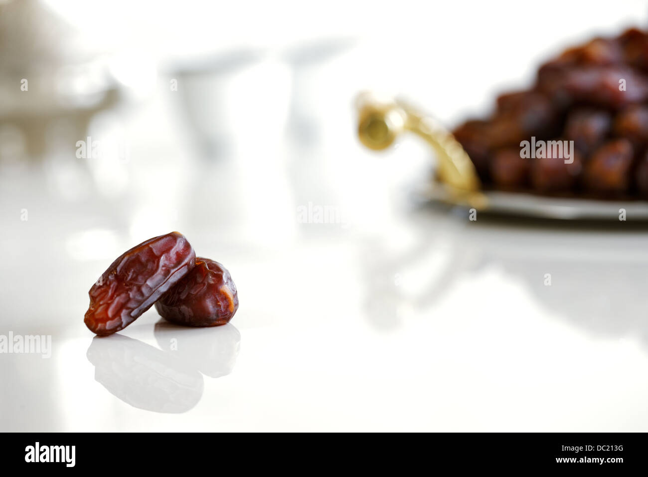 Dried Arabic dates presented on an ornate tray and shot against a white background Stock Photo