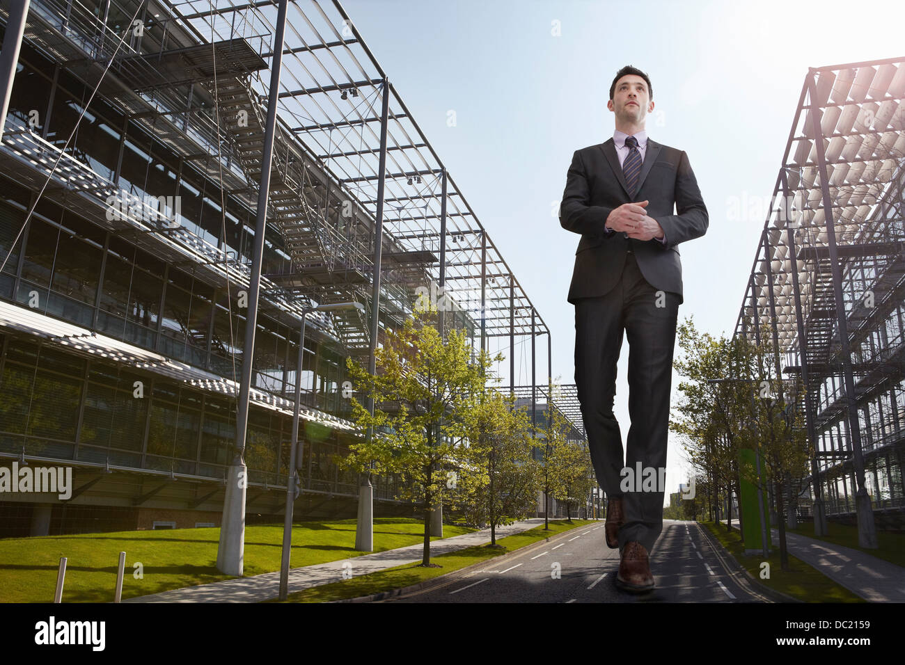 Oversized businessman walking on road, low angle view Stock Photo