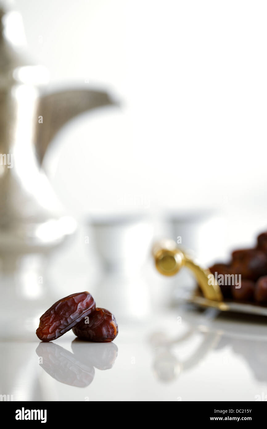 Dried Arabic dates presented on an ornate tray and shot against a white background Stock Photo