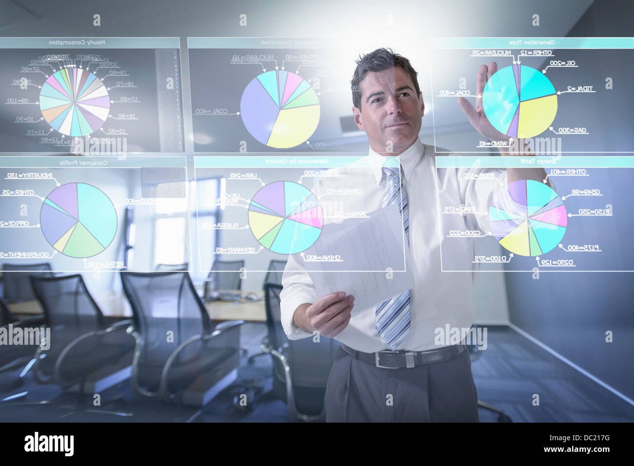 Businessman looking at pie charts on interactive screen Stock Photo