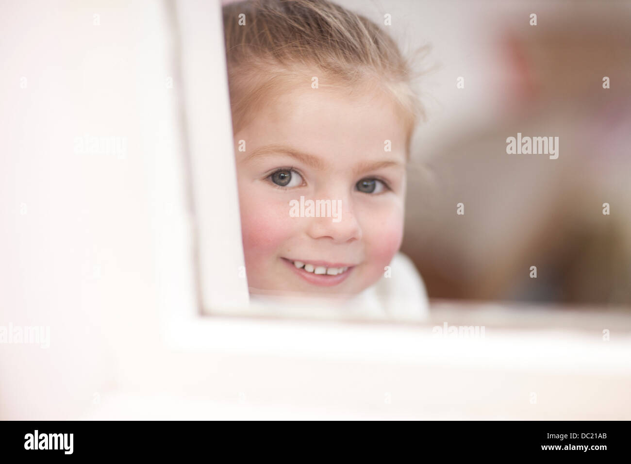 Close up of young girl looking through window at ballet class Stock Photo