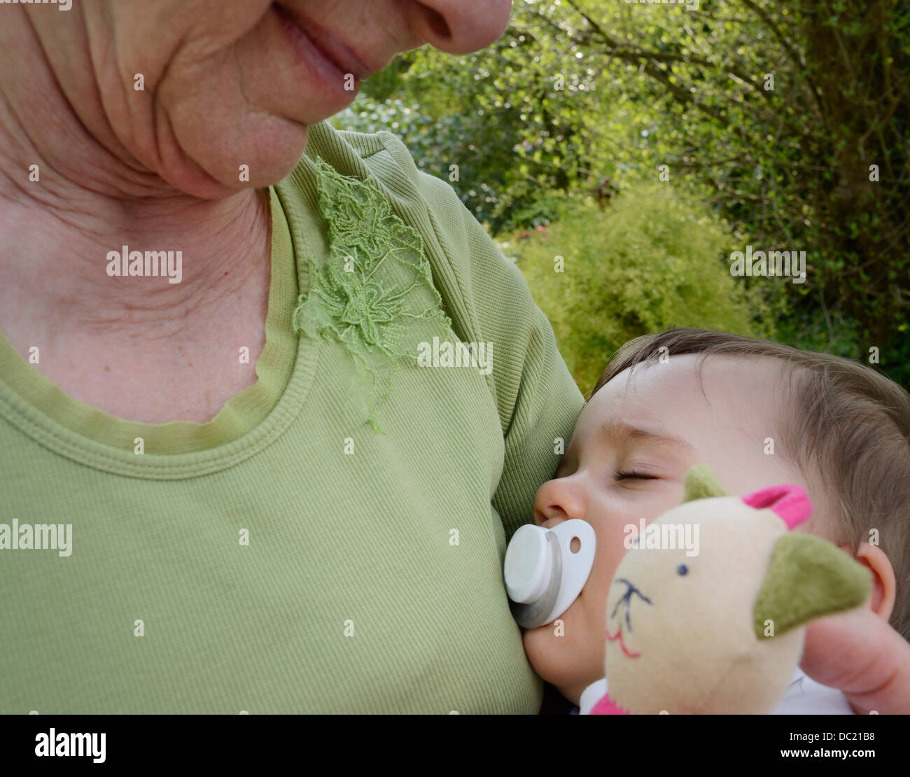 Senior woman holding sleeping granddaughter, close up Stock Photo