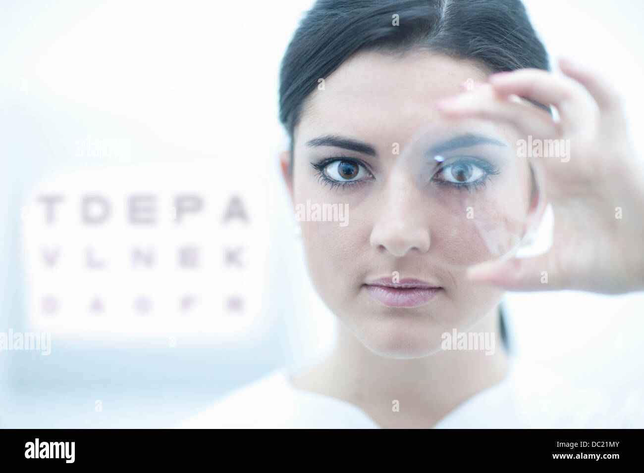 Close up of optician holding lens in eye clinic Stock Photo Alamy