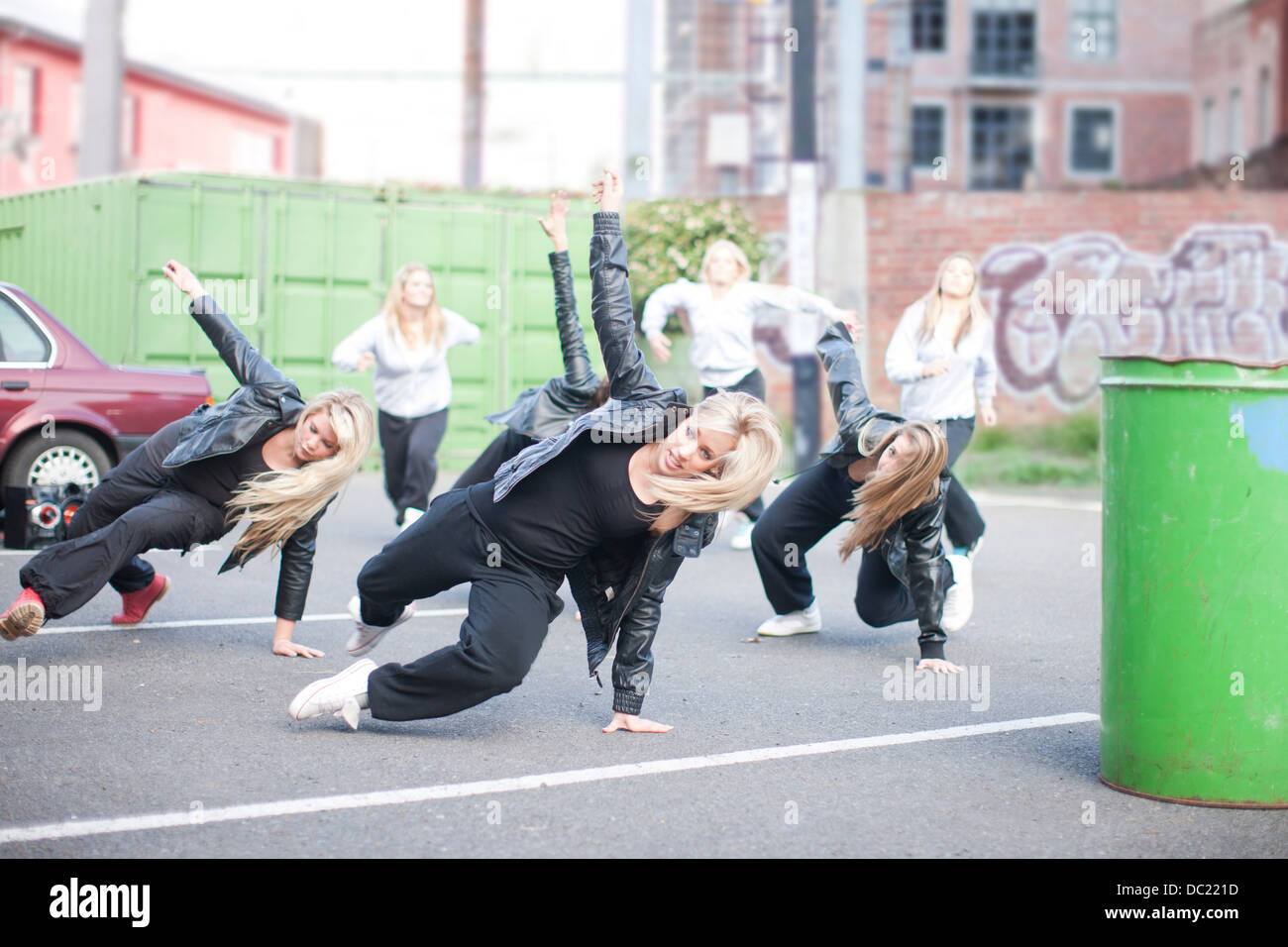 Girls practicing dance moves in carpark Stock Photo