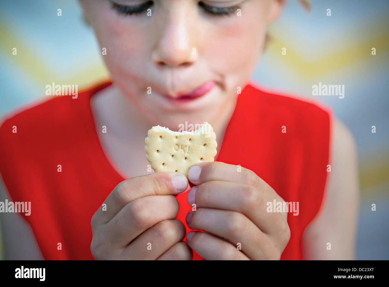 Boy holding biscuit that says 'OK!' Stock Photo