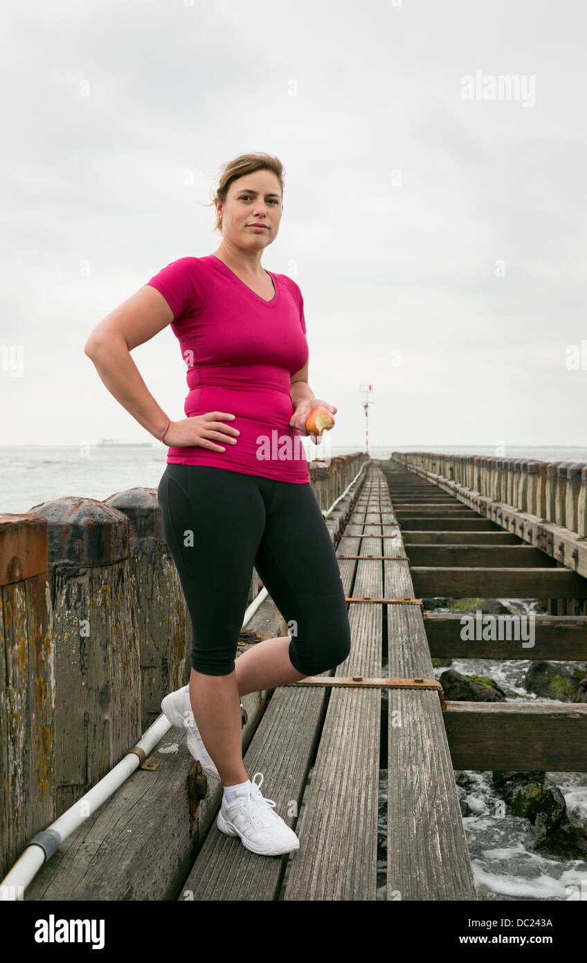 Woman standing on pier wearing sports clothing Stock Photo