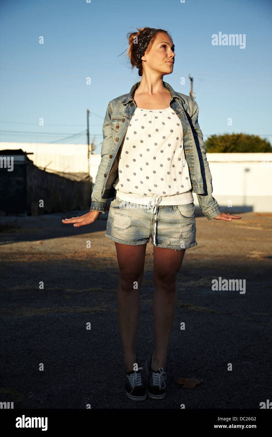 Woman standing in industrial area with hands to side Stock Photo