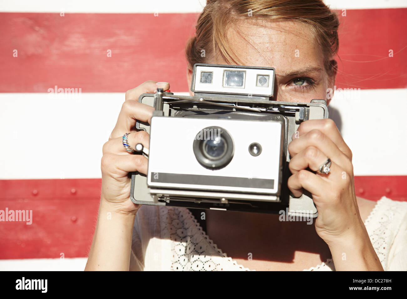 Woman taking photograph using vintage camera Stock Photo