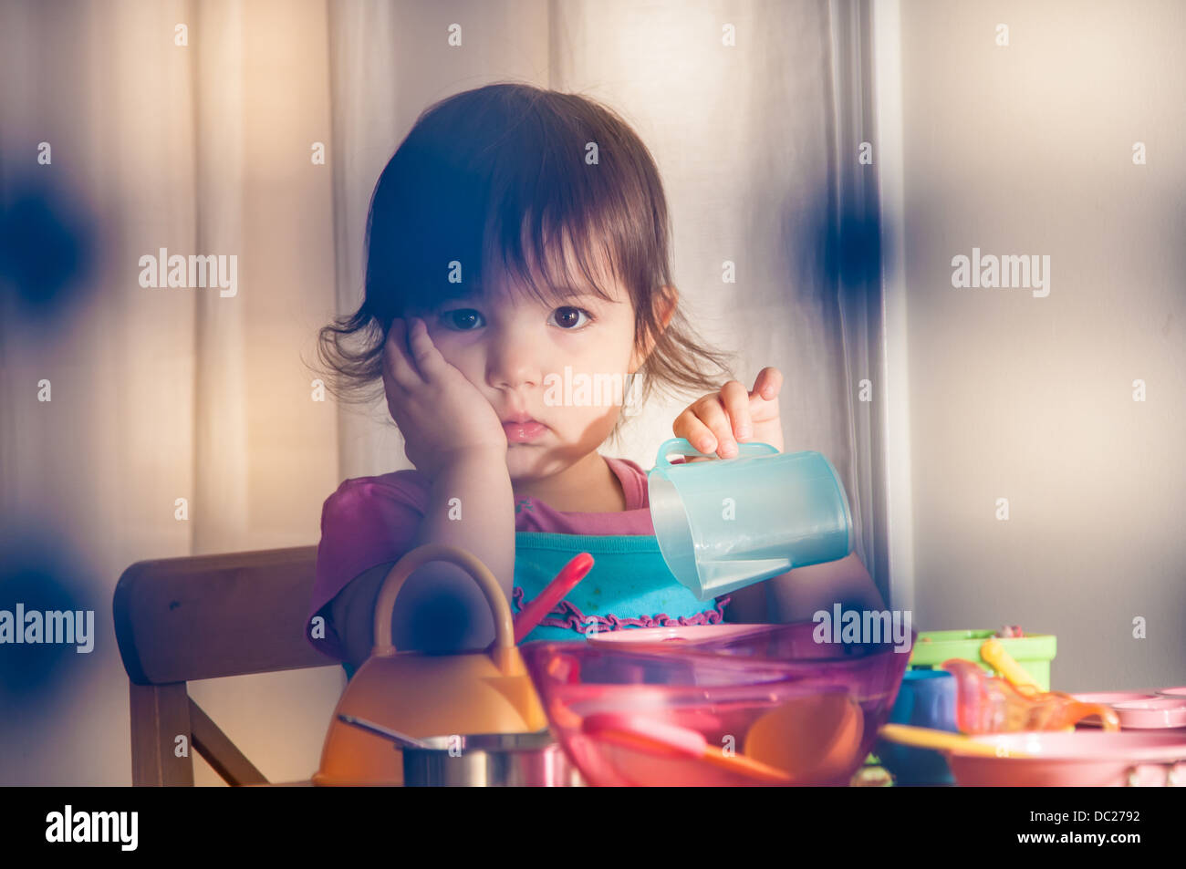 Sad girl playing with toys Stock Photo