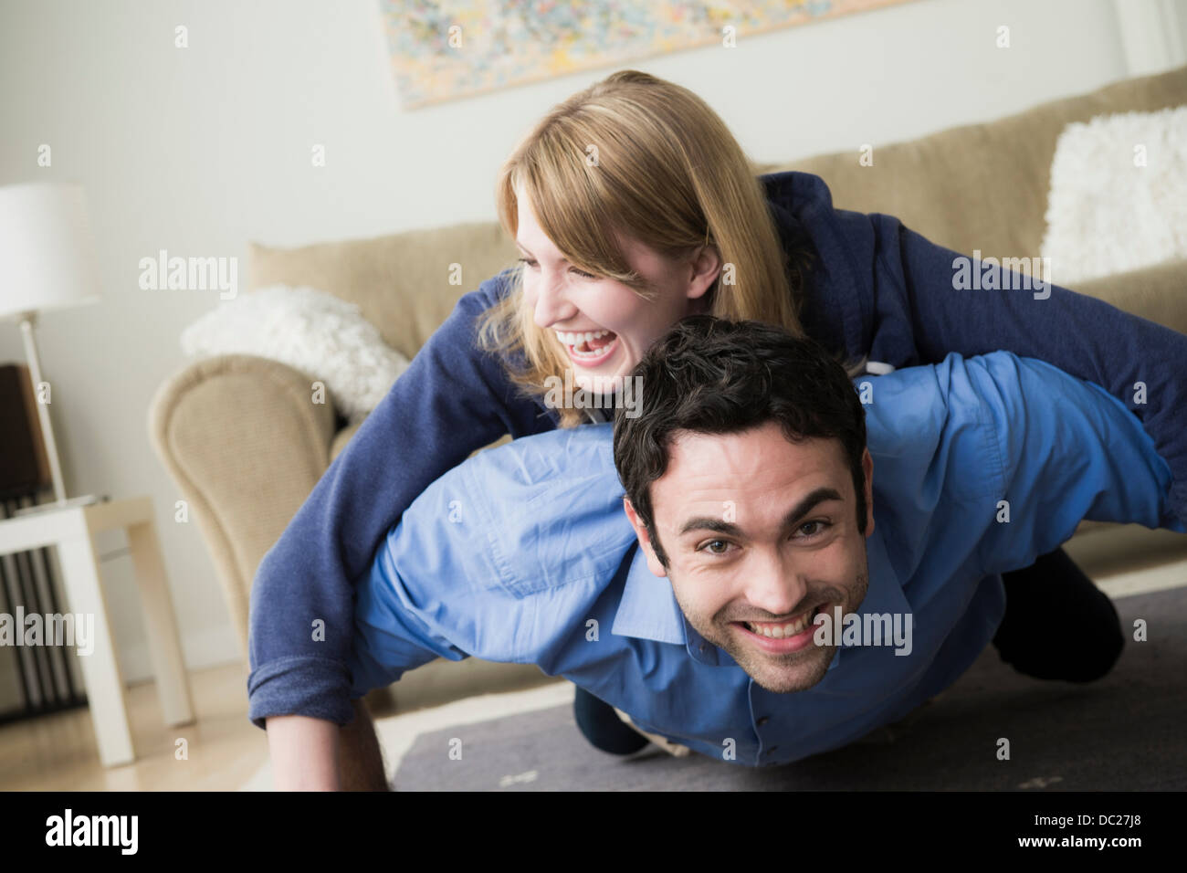 Young couple lying on floor, woman on top of man Stock Photo ...