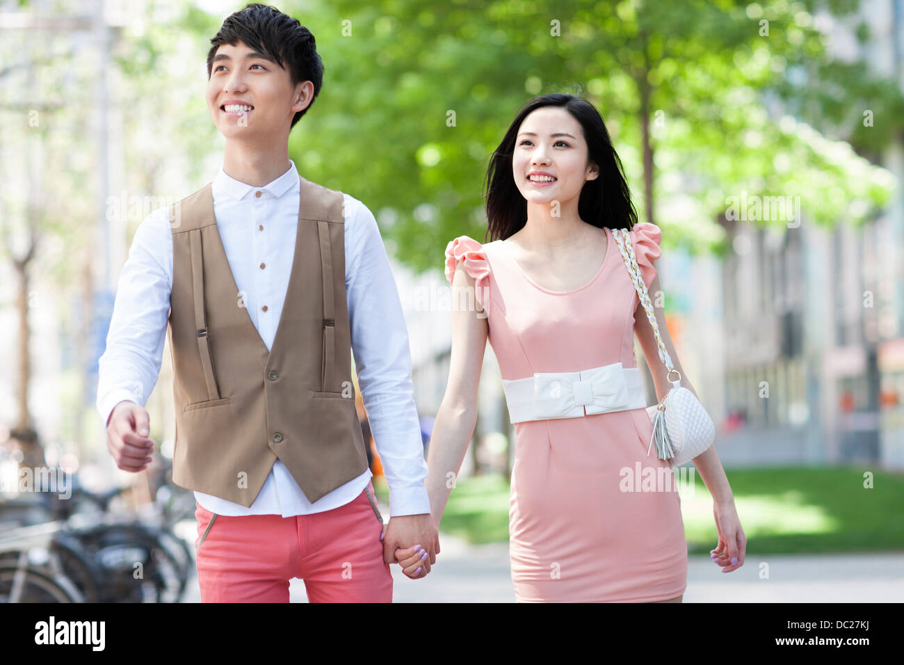 Happy young couple walking hand in hand Stock Photo - Alamy