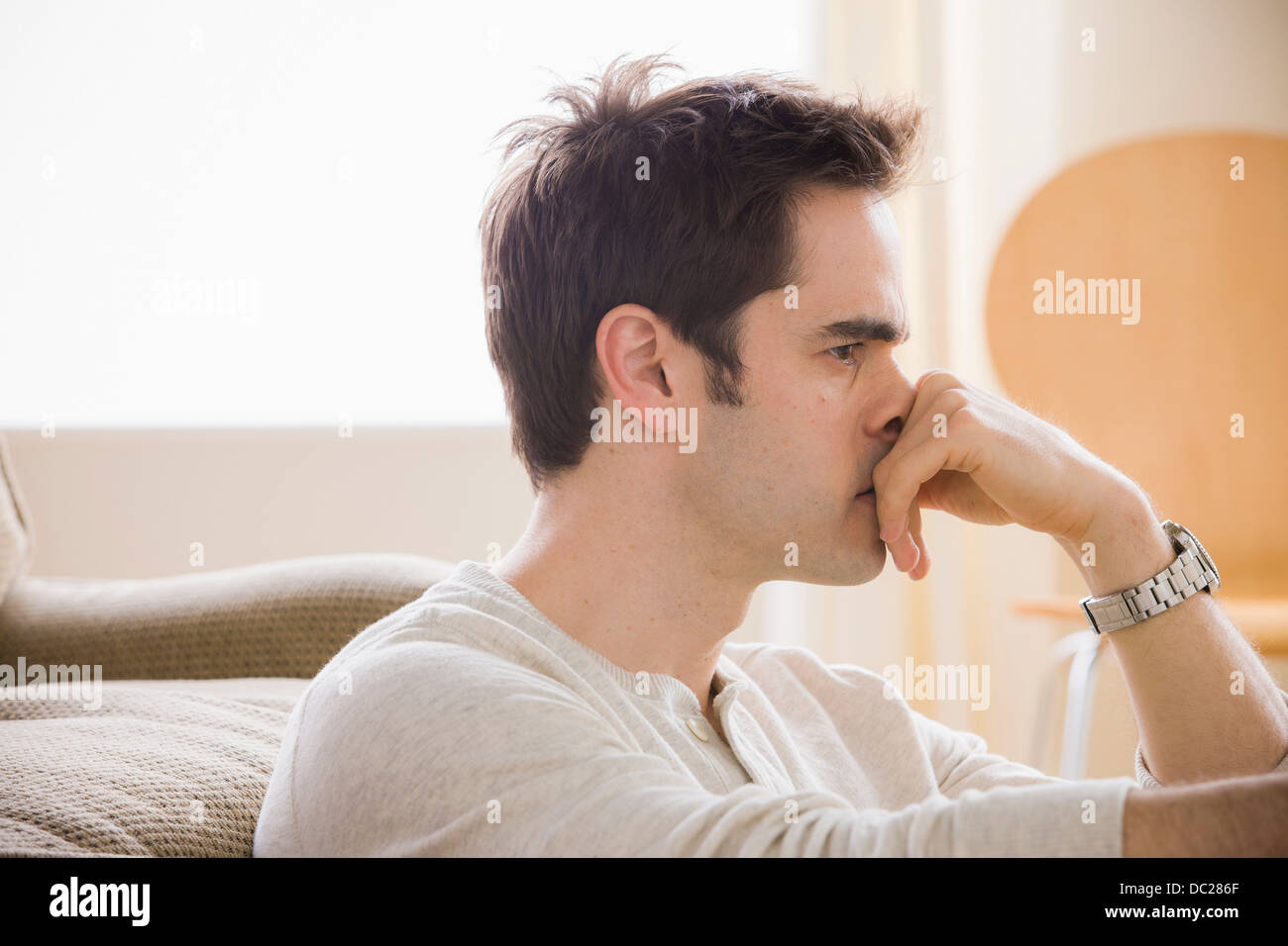 Mid adult man with hand on chin Stock Photo