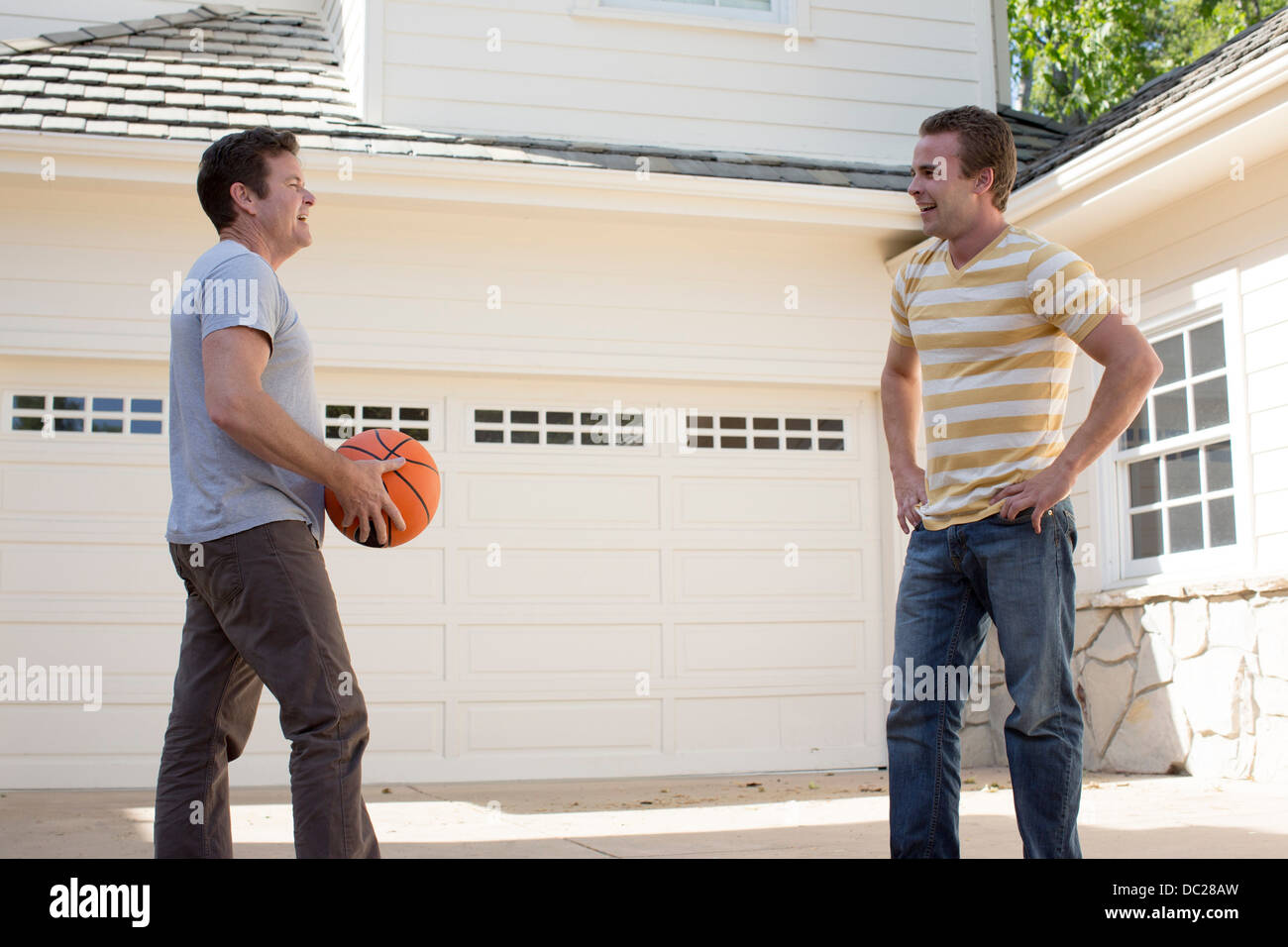 Father holding basketball with adult son Stock Photo