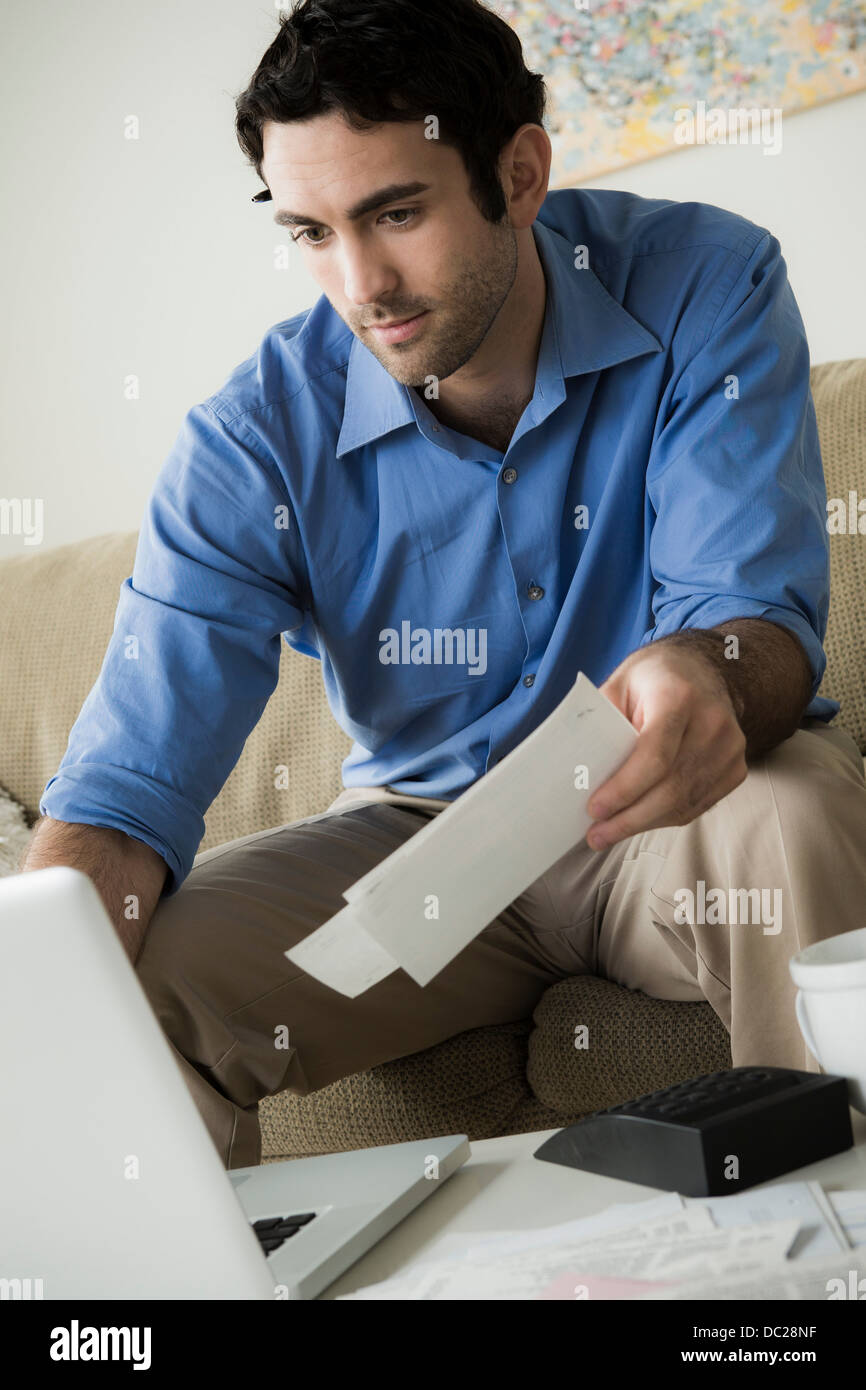 Young man paying bills online Stock Photo