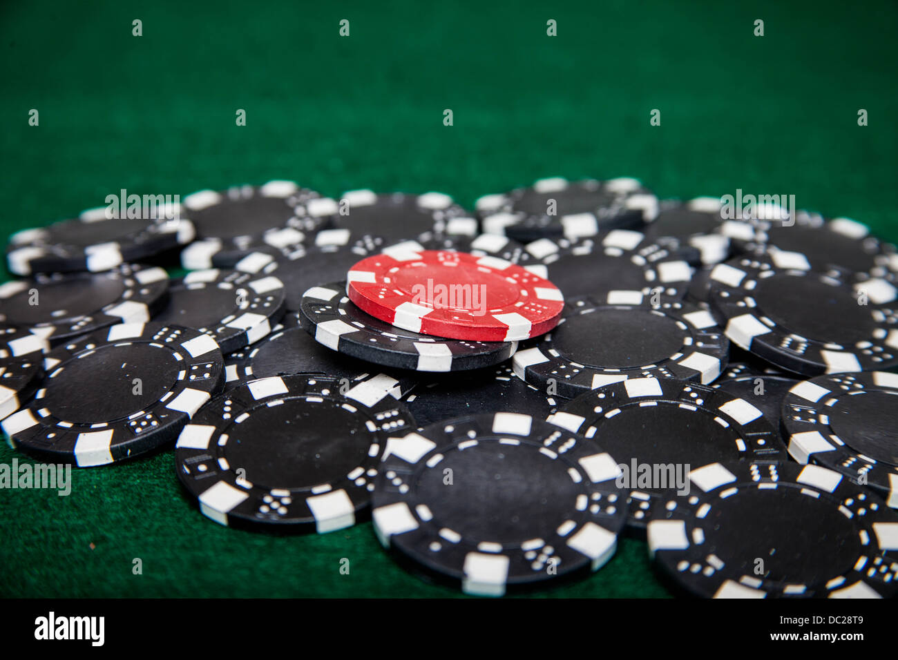 Red poker chip on pile of black poker chips Stock Photo Alamy