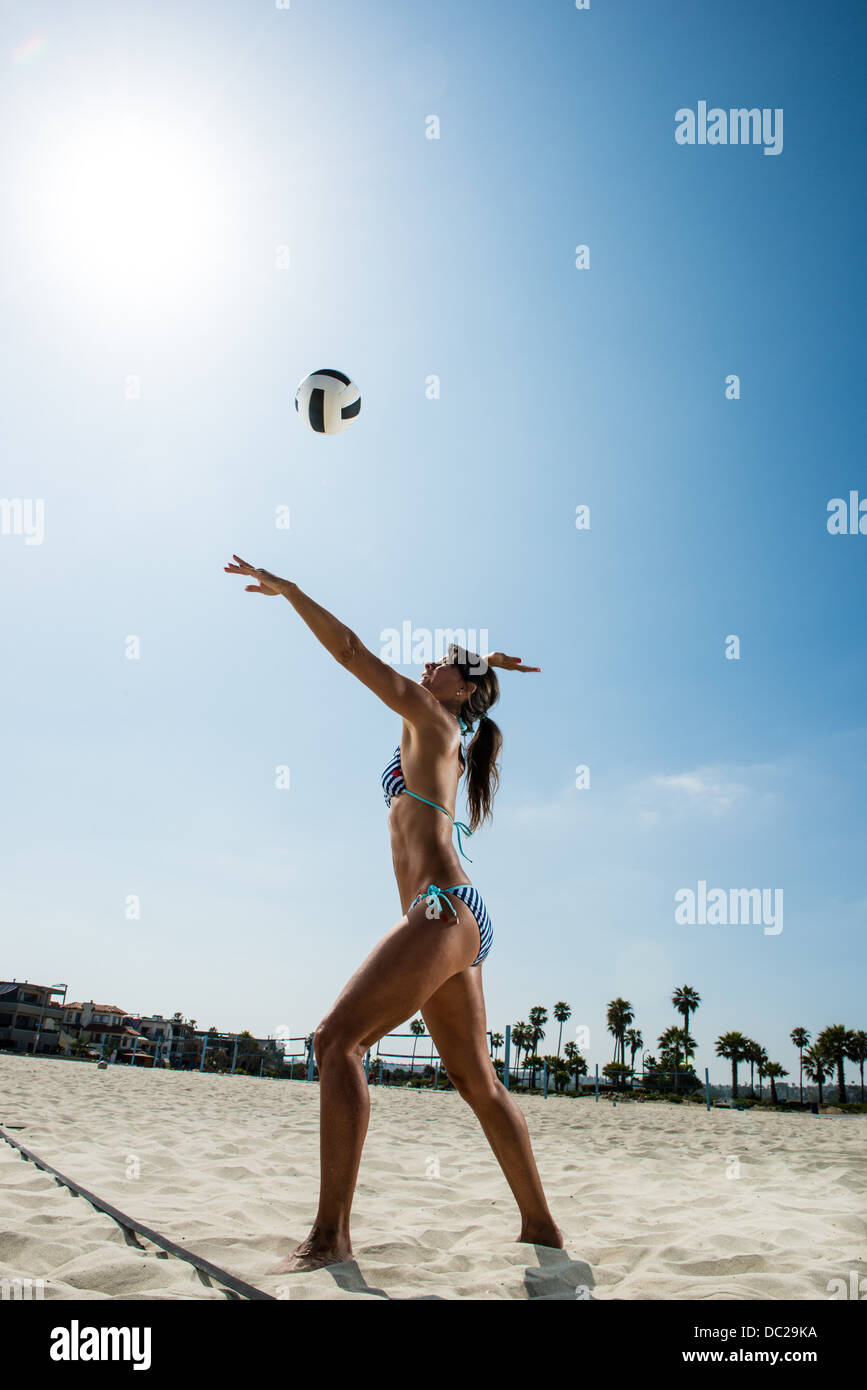 Female beach volleyball player hitting ball Stock Photo