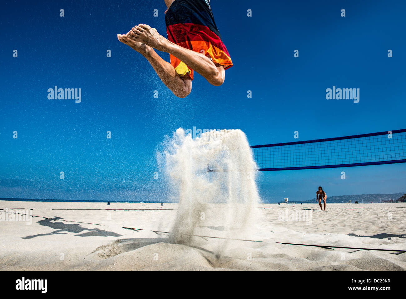 Male beach volleyball player jumping mid air Stock Photo Alamy