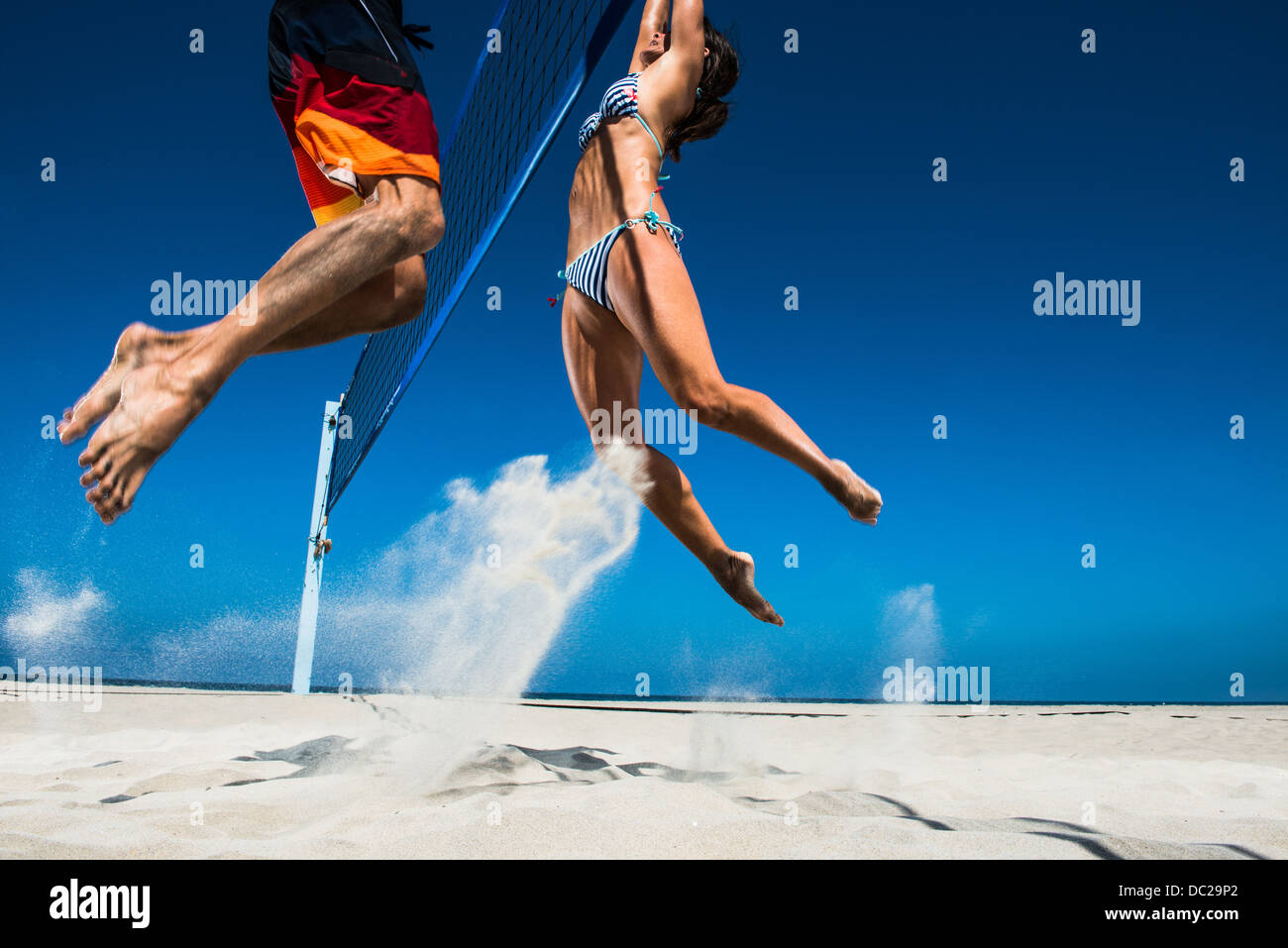 Two beach volleyball players blocking at net Stock Photo