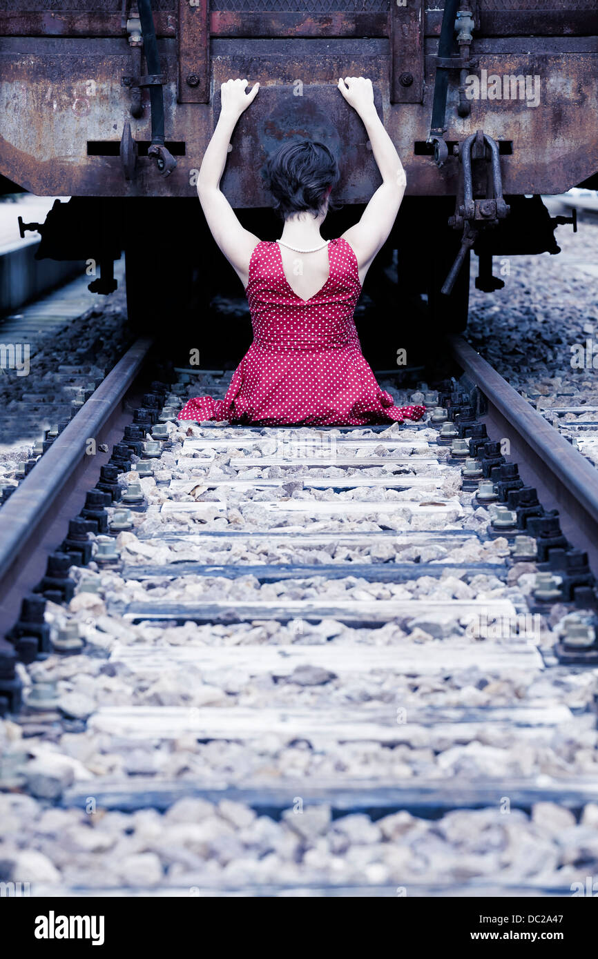 a girl in a red dress is hanging on a wagon Stock Photo
