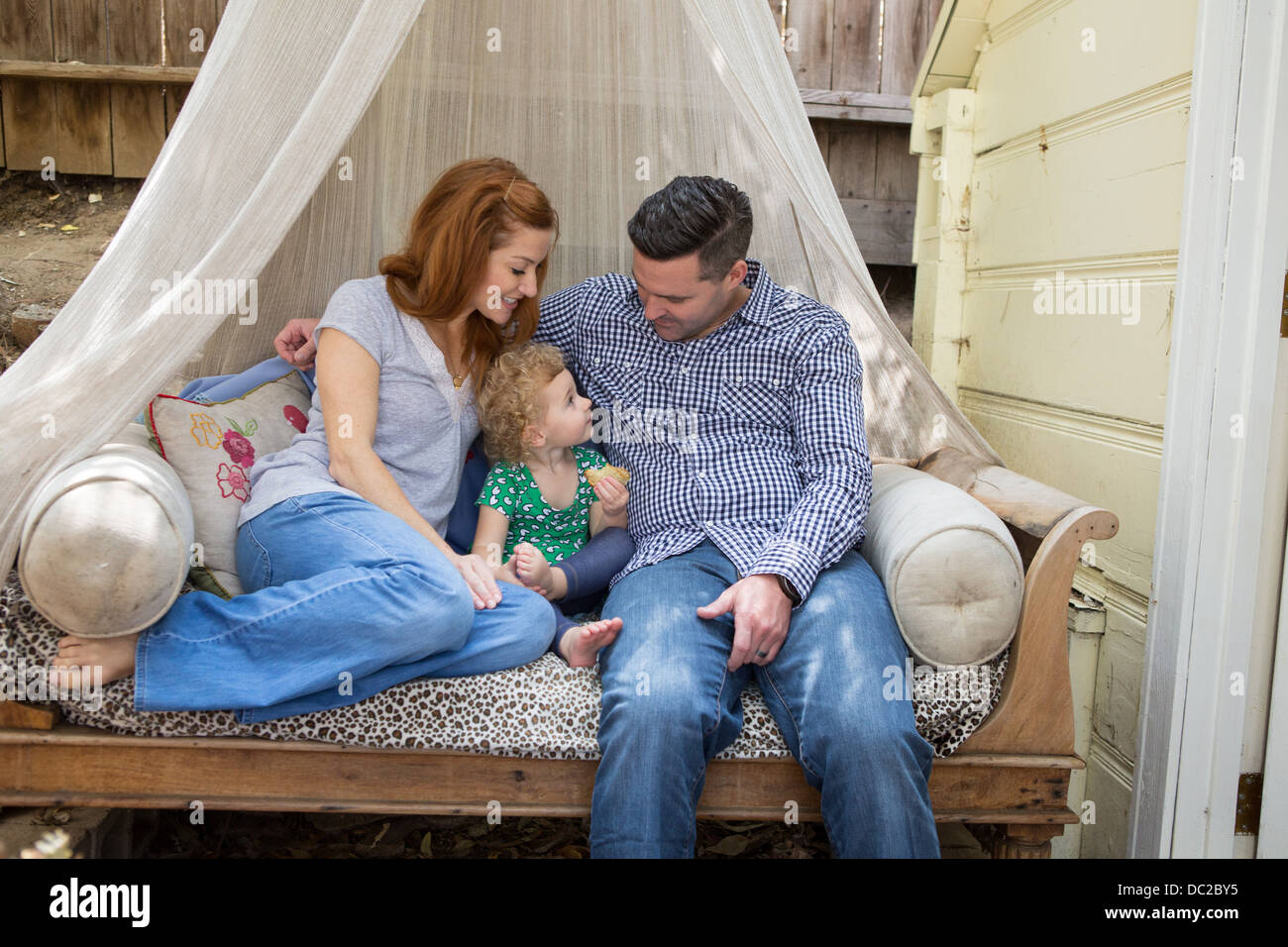 Couple on daybed with child Stock Photo Alamy