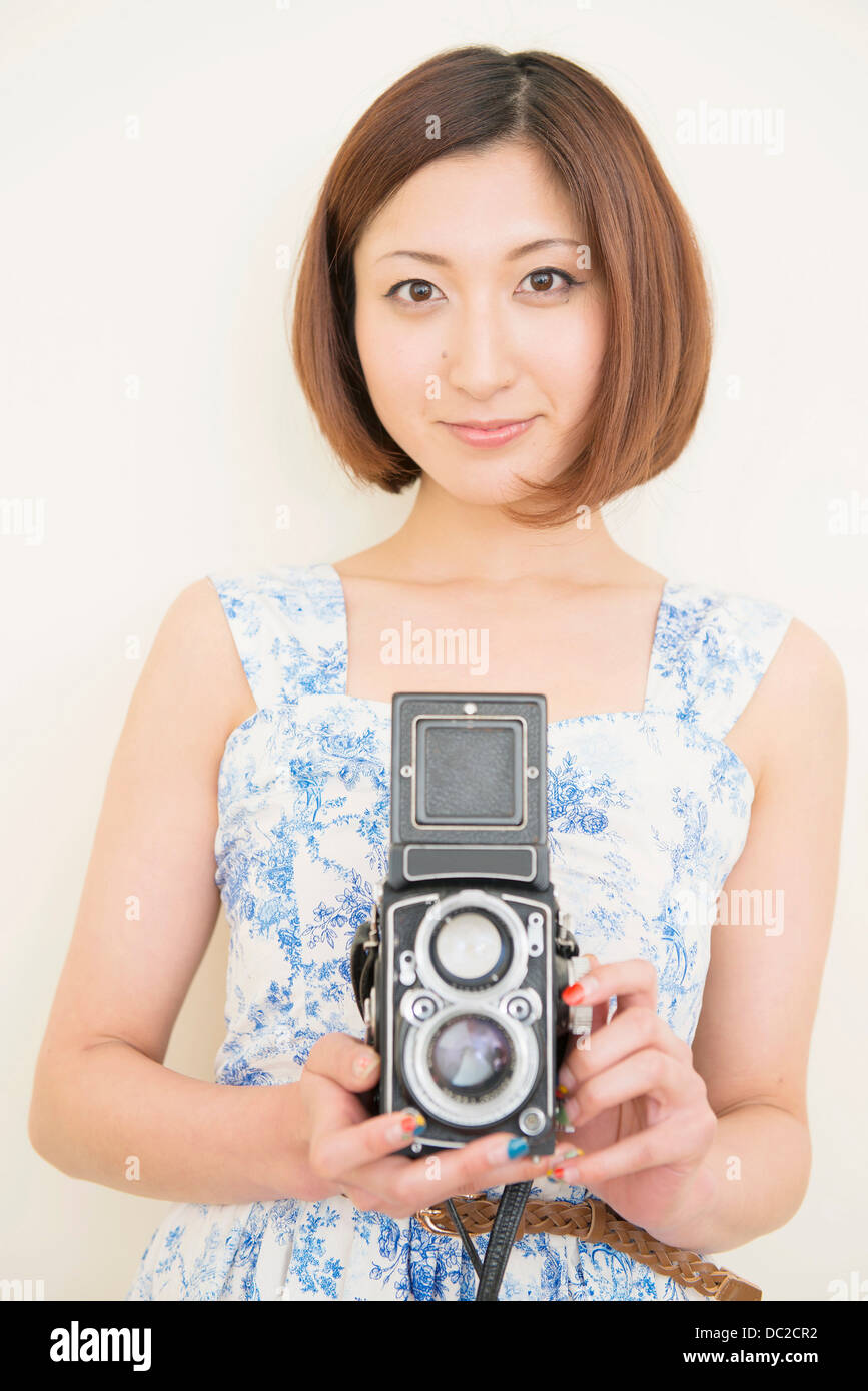 Smiling woman holding a 1960's classic camera Stock Photo