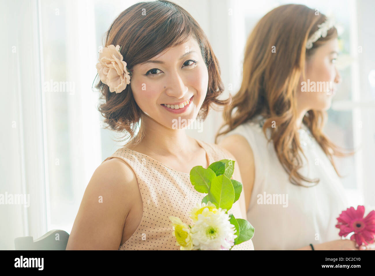 Smiling woman with flower looking at camera Stock Photo