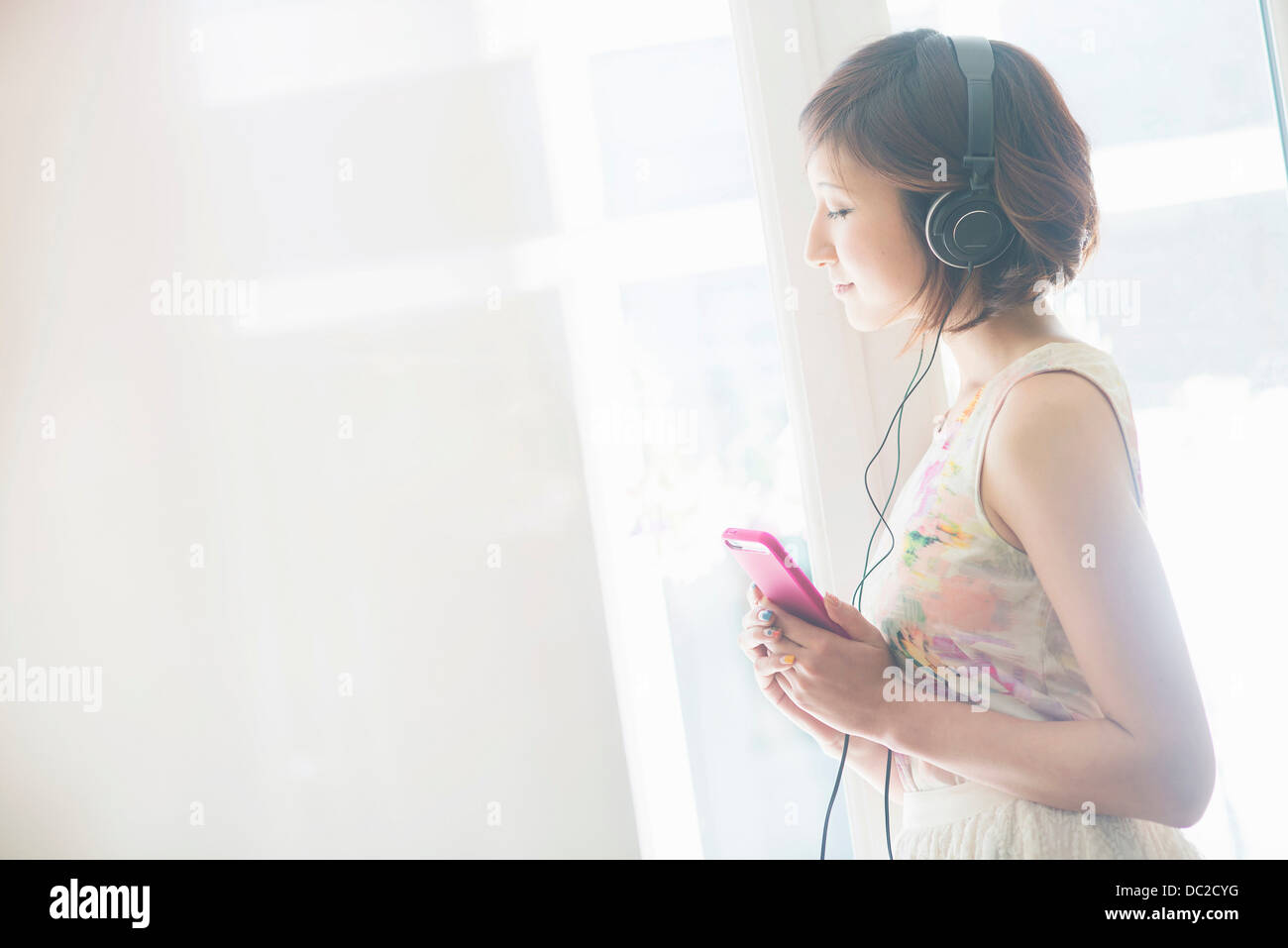 Woman listening to music on mobile phone with earphones Stock Photo