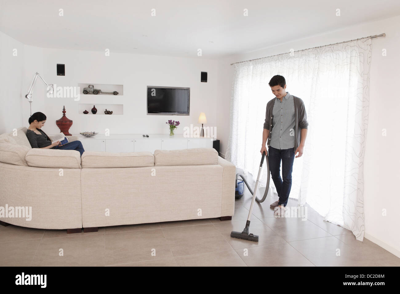 Man vacuuming living room floor Stock Photo - Alamy