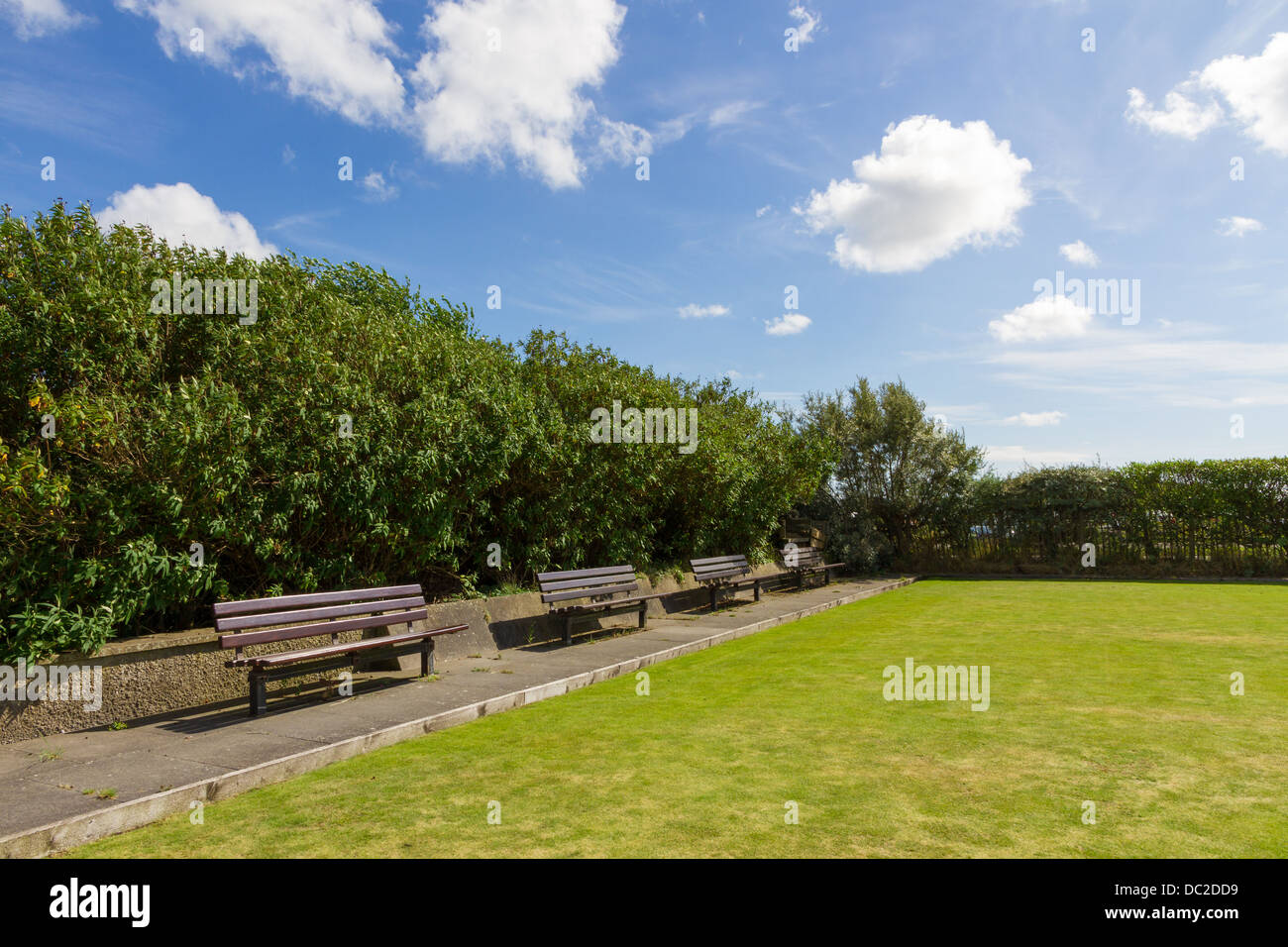 Wooden benches by the side of a bowling green in Glasson Dock, Lancashire, England. Stock Photo