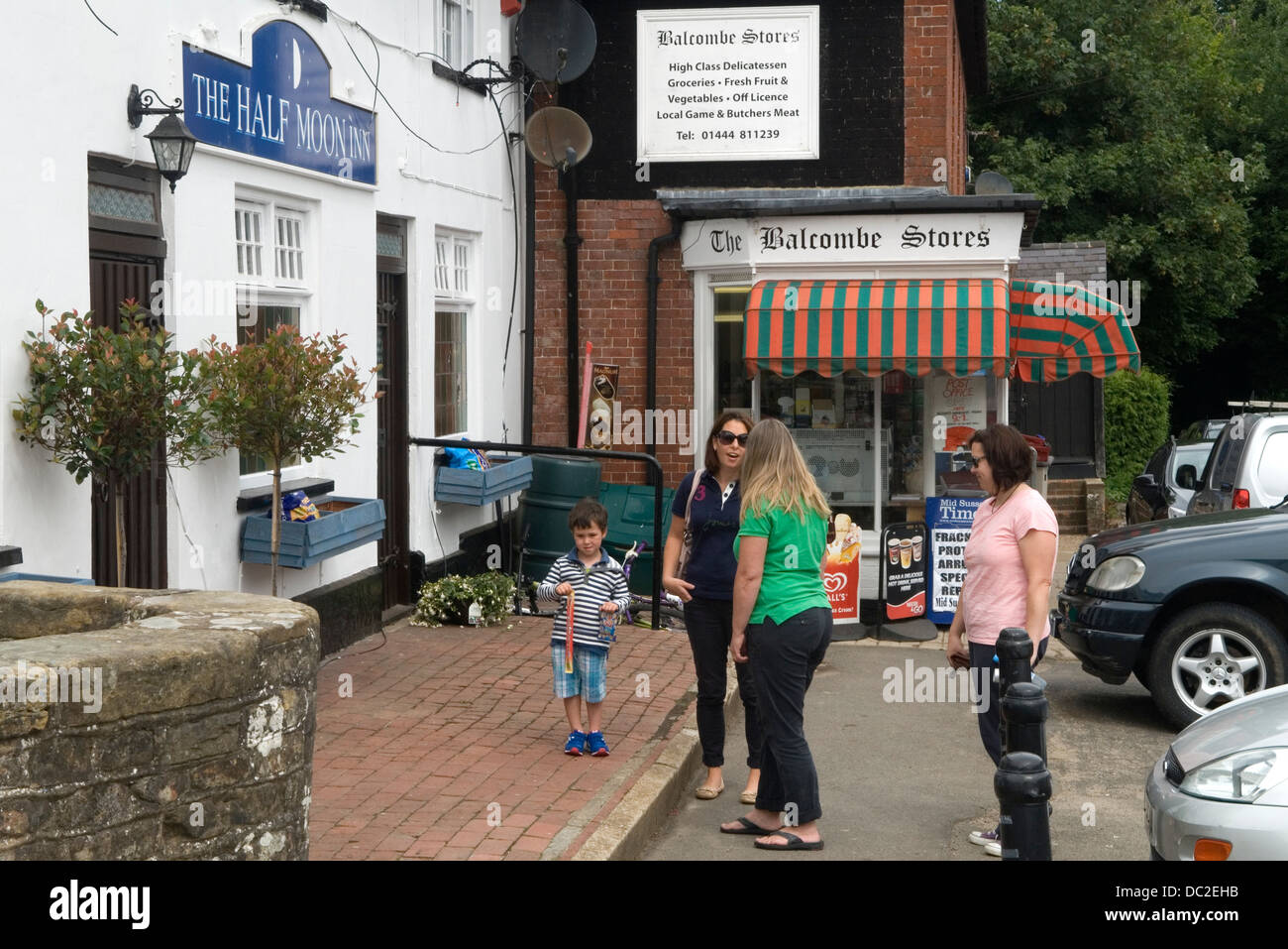 Balcombe West Sussex UK. Local residents chat iin the vilage outside the Balcombe Stores and the village pub The Half Moon Inn. Stock Photo
