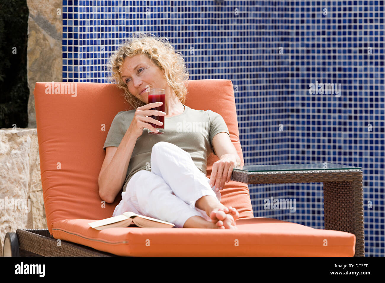 A woman relaxing on a sun lounger Stock Photo - Alamy