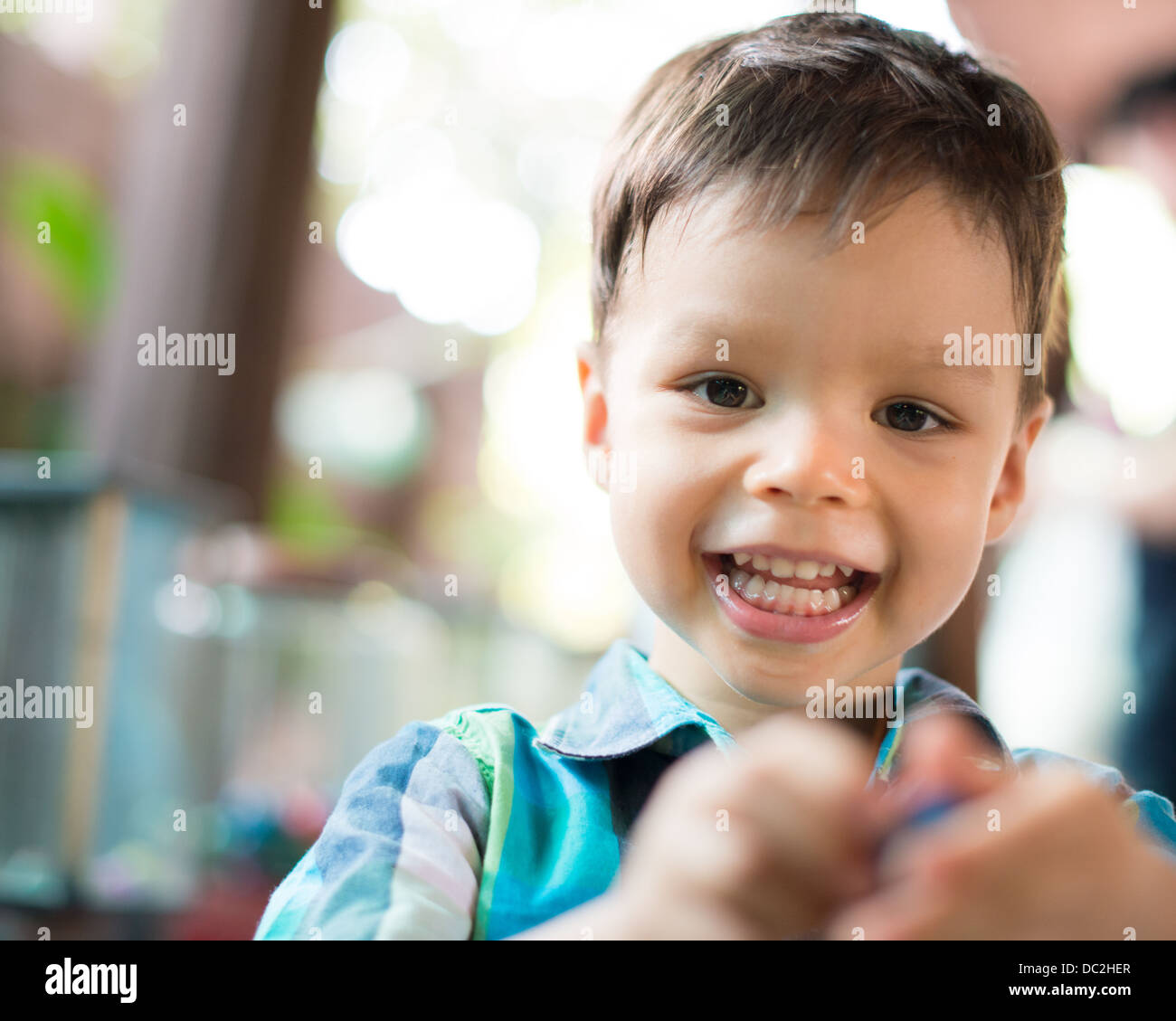 Series of photos of a 2 year old mixed race Asian Caucasian child enthusiastically getting a toy from a vintage vending machine Stock Photo