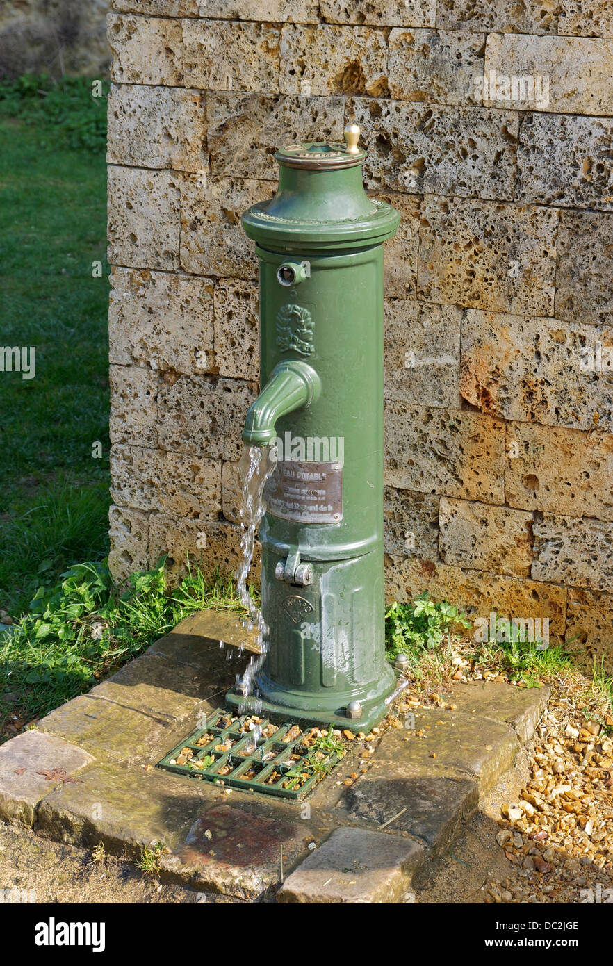 A public fountain 'Bayard' with a crank, working. Courtyard of the Château de la Madeleine, Chevreuse, Yvelines, France. Stock Photo