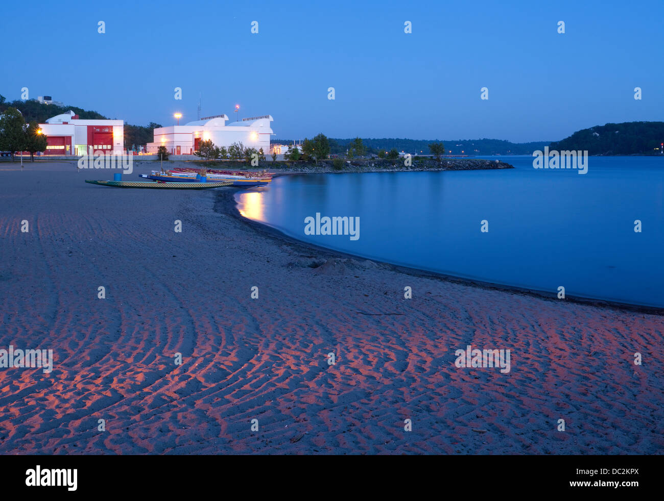 Dragon boats on the beach at dusk in Parry Sound, Ontario, Canada. Stock Photo