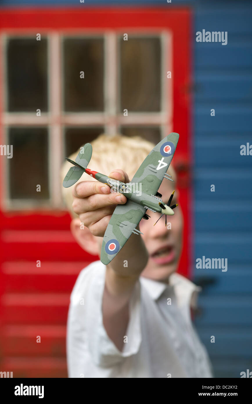 Boy playing with model Spitfire plane Stock Photo