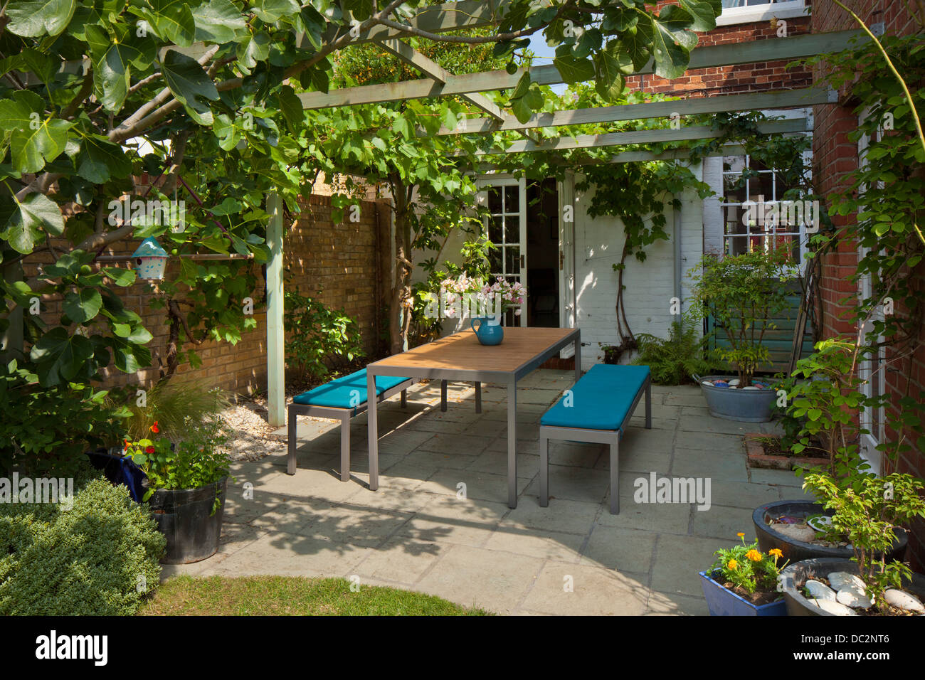 Contemporary garden furniture under wooden pergola and shady patio in English garden, England Stock Photo
