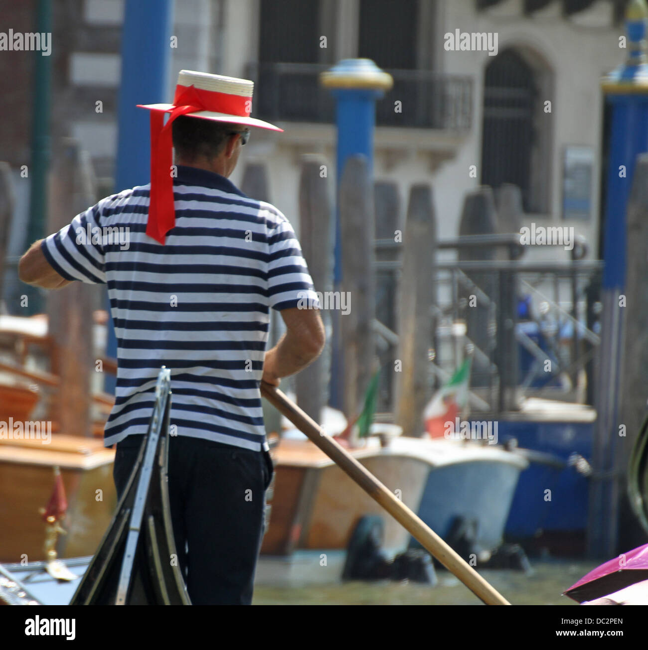 skilled Venetian gondolier as he drives his gondola on the Grand canal in Venice Stock Photo