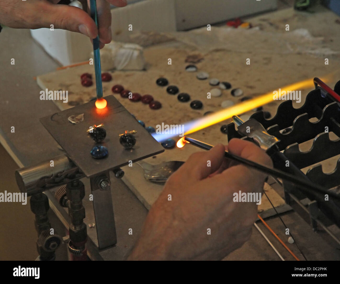 Glazier with gas torch lit while blending and shaping a piece of glass 3 Stock Photo