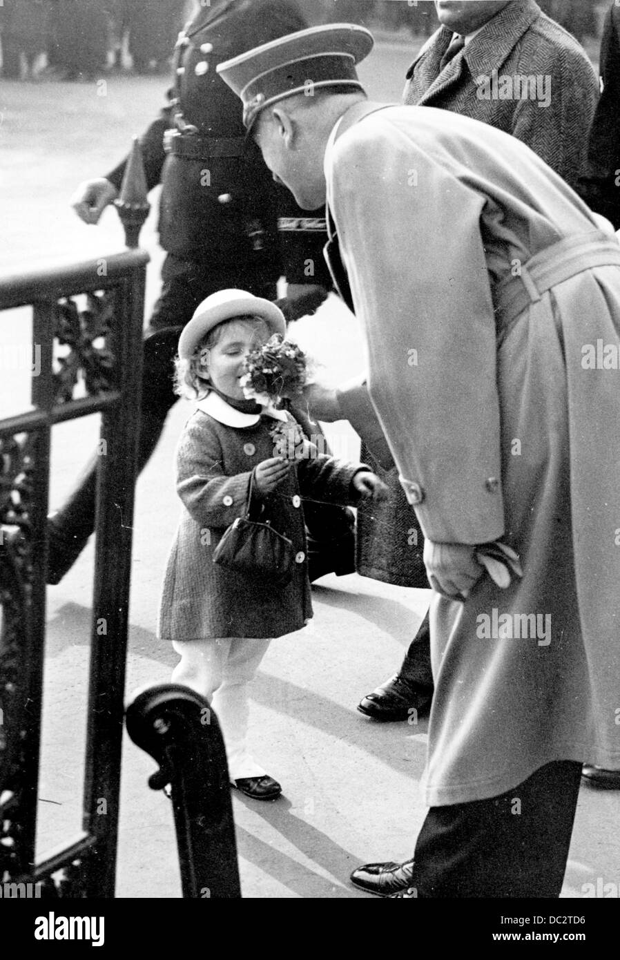 The image from the Nazi Propaganda! shows Adolf Hitler receiving flowers from a little girl on his way to a reception at the Ministry of Public Enlightenment and Propaganda in Berlin, Germany, on the occasion of Joseph Goebbel's 40th birthday on 29 October 1937. Fotoarchiv für Zeitgeschichte Stock Photo